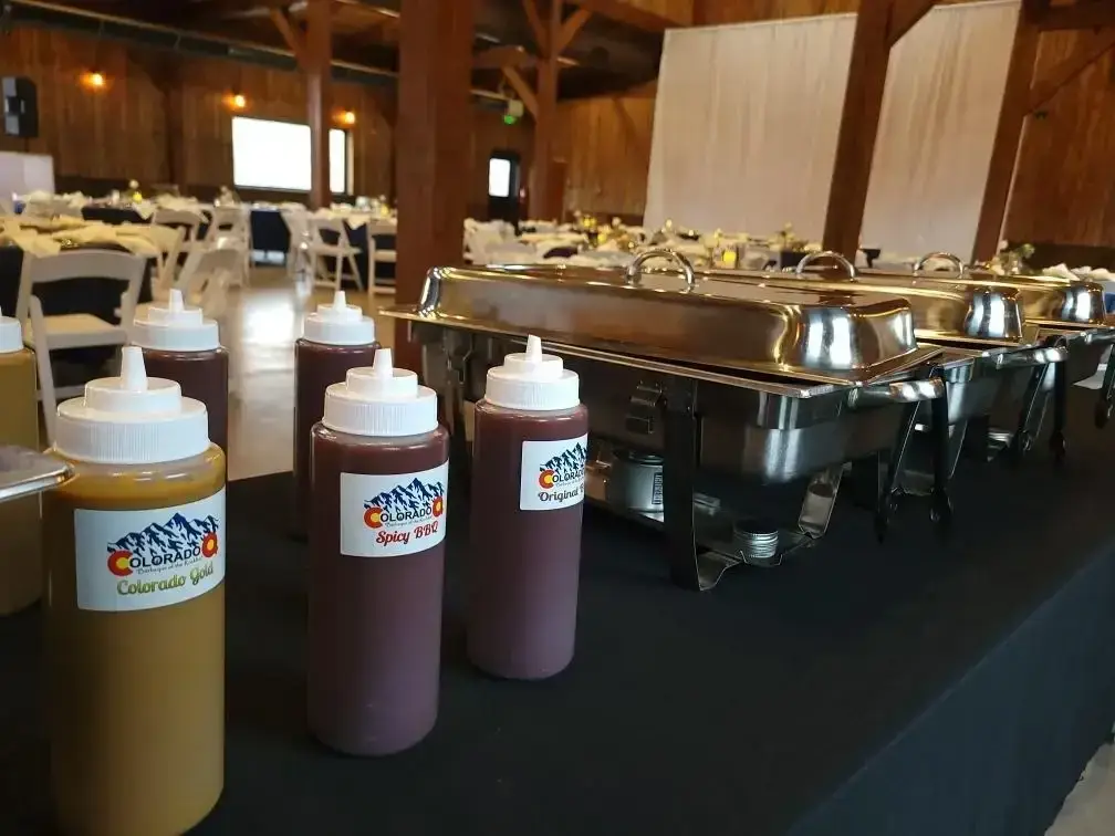 Colorado Q sauce bottles alongside covered buffet trays